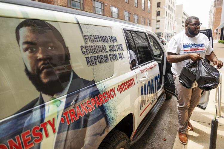 Alfred Montgomery collects campaign signs after upsetting St. Louis Sheriff Vernon Betts